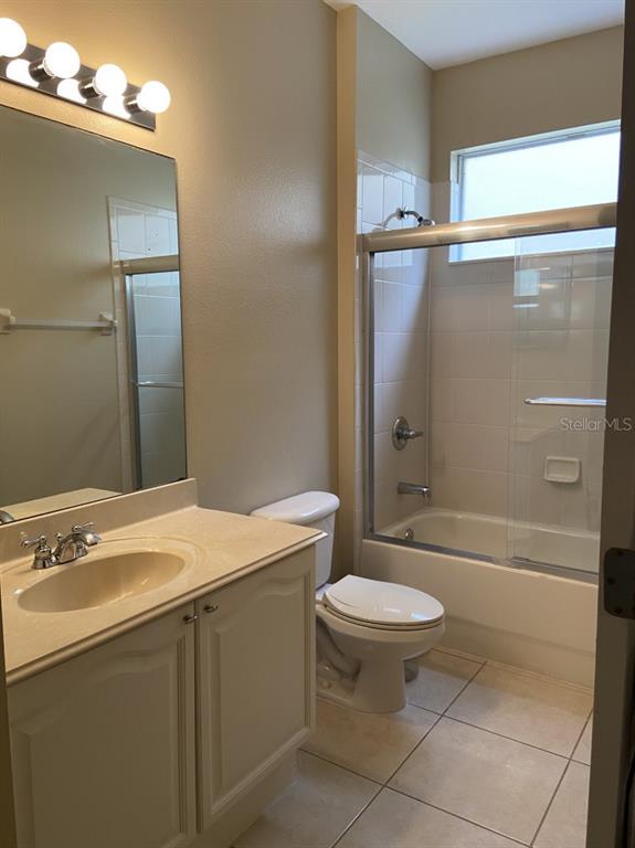 A bathroom features a vanity with a sink, a toilet, and a shower-tub combination — 6679 DUNCASTER STREET, WINDERMERE, FL