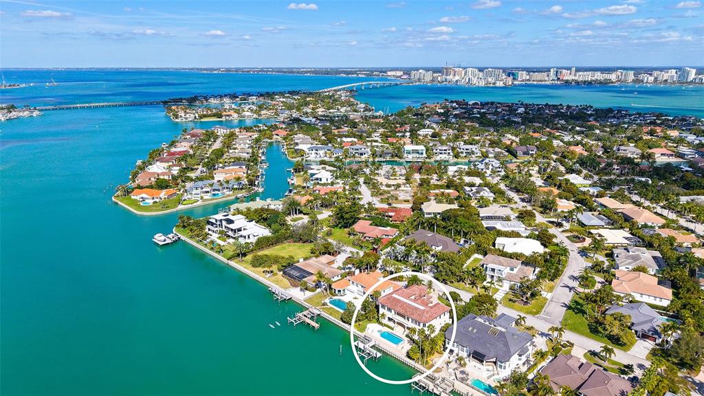 An aerial view of a waterfront house with a pool and dock in a neighborhood — 570 S SPOONBILL DRIVE, SARASOTA, FL