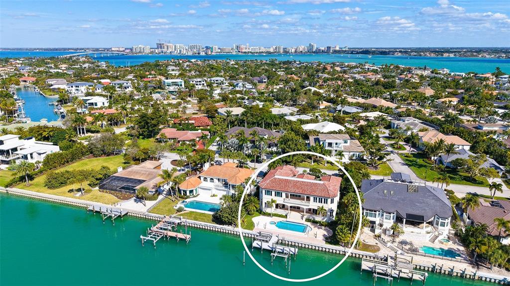 An aerial view of a waterfront mansion with a red tile roof and swimming pool — 570 S SPOONBILL DRIVE, SARASOTA, FL