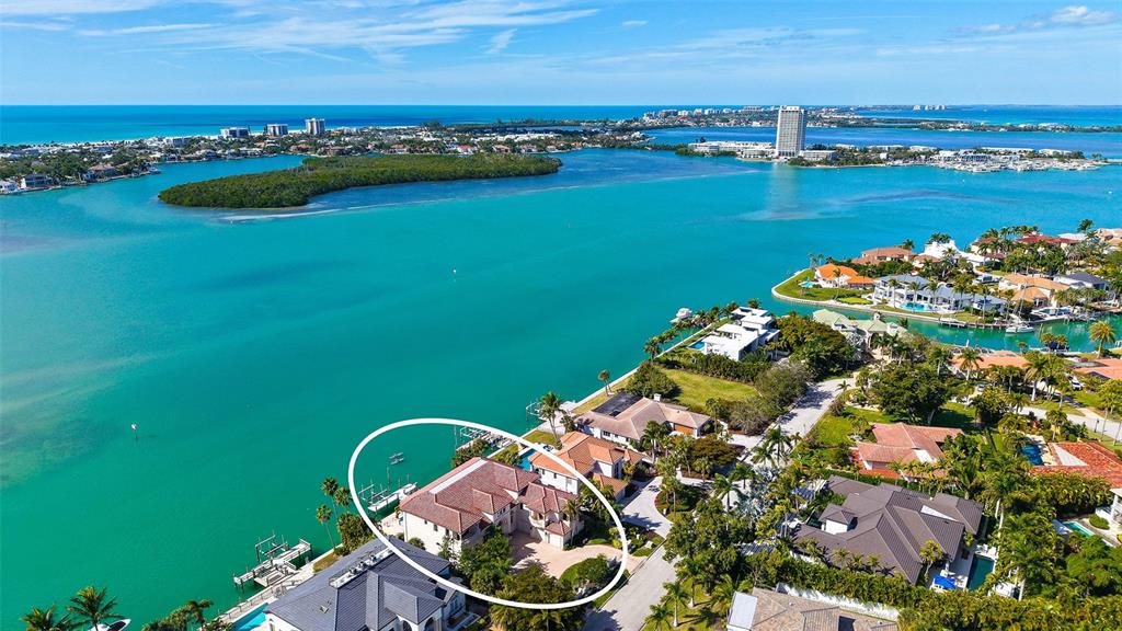 An aerial view shows a waterfront house with a tiled roof and a private dock — 570 S SPOONBILL DRIVE, SARASOTA, FL