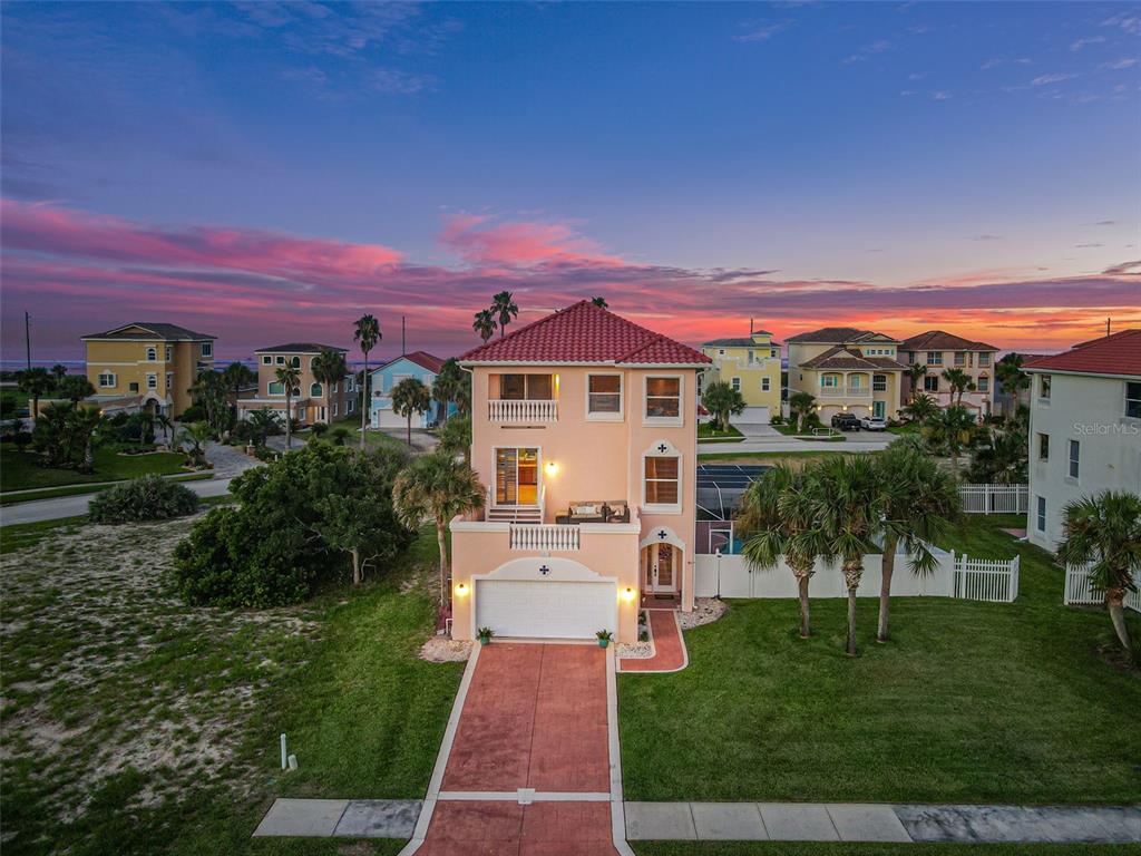 An aerial view of a multi-story peach-colored house with a red tile roof at sunset — 3817 ISLAMORADA DRIVE, ORMOND BEACH, FL