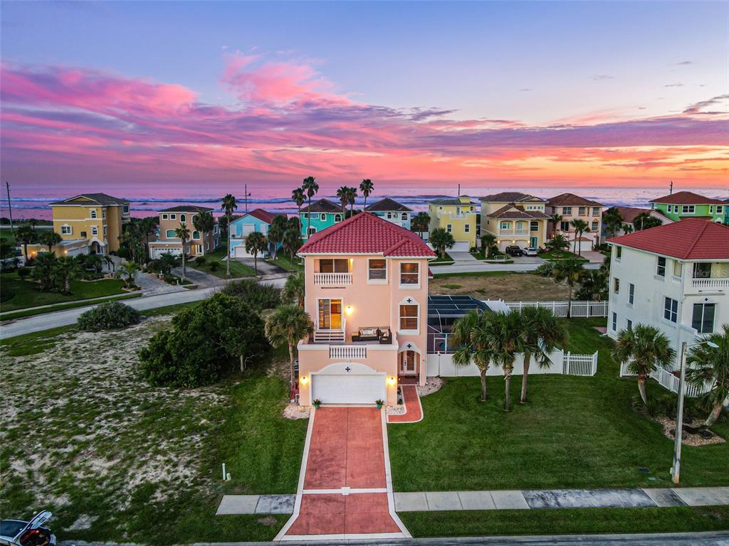 An aerial view of a three-story peach-colored house with a red tile roof near the ocean — 3817 ISLAMORADA DRIVE, ORMOND BEACH, FL
