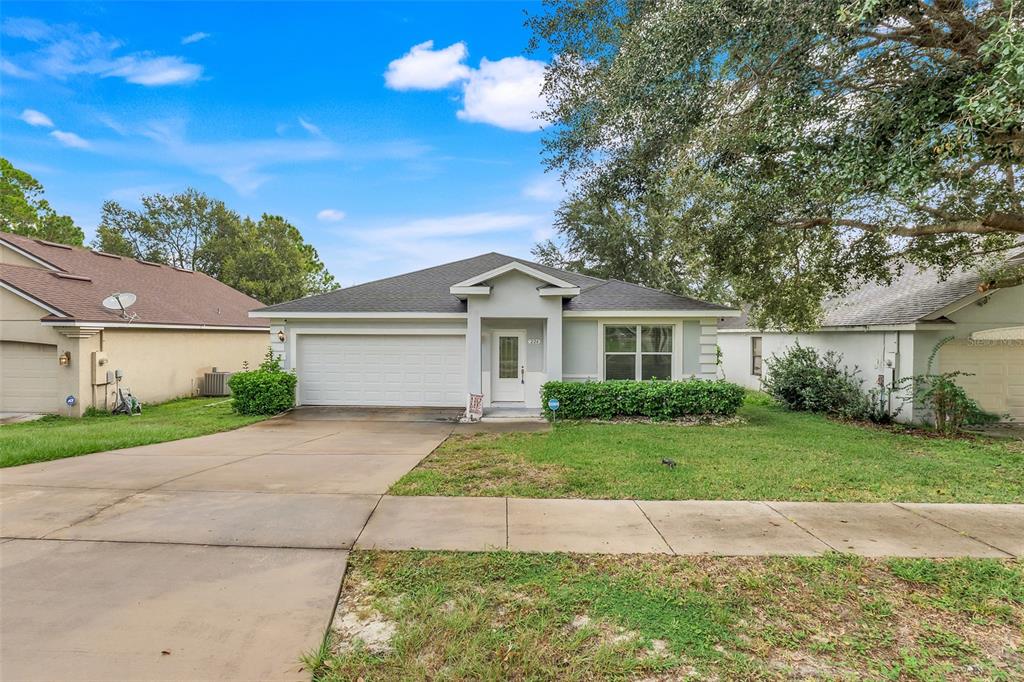 A single-story house with a white garage, gray roof, and a concrete driveway — 226 HAVERSHAM ROAD, DELTONA, FL