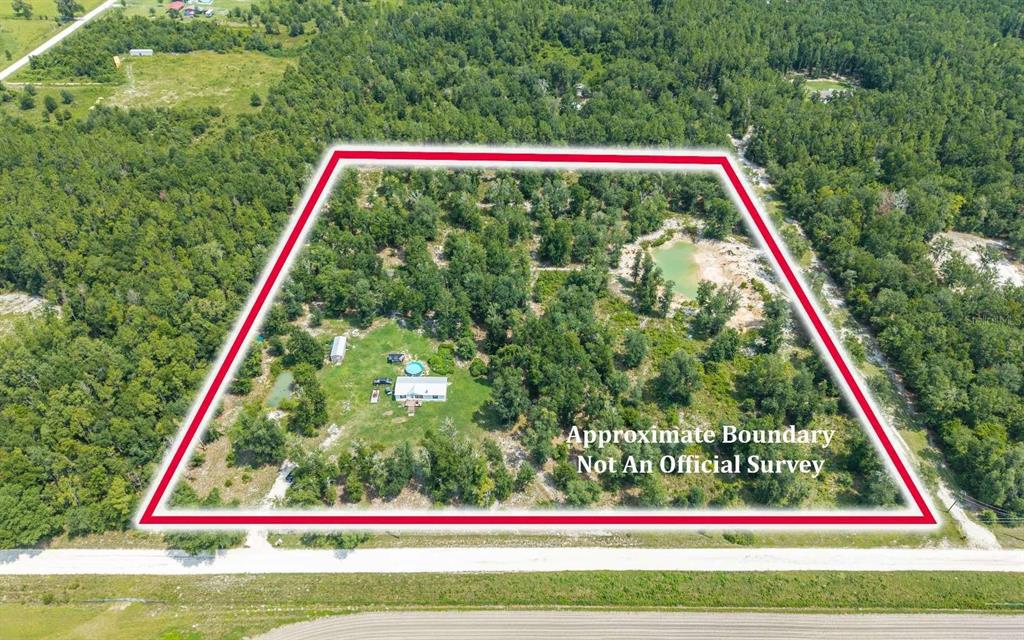 An aerial view shows a house and a small pond on a wooded, rectangular lot — 12329 176TH STREET, MC ALPIN, FL