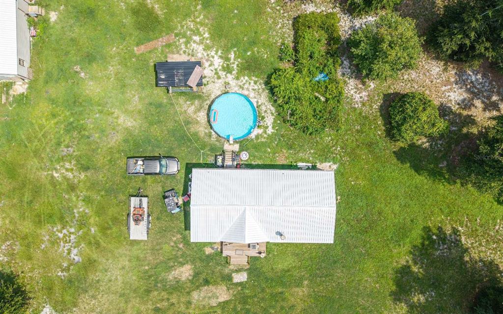 An aerial view shows a house with a metal roof, a pool, and a parked truck — 12329 176TH STREET, MC ALPIN, FL