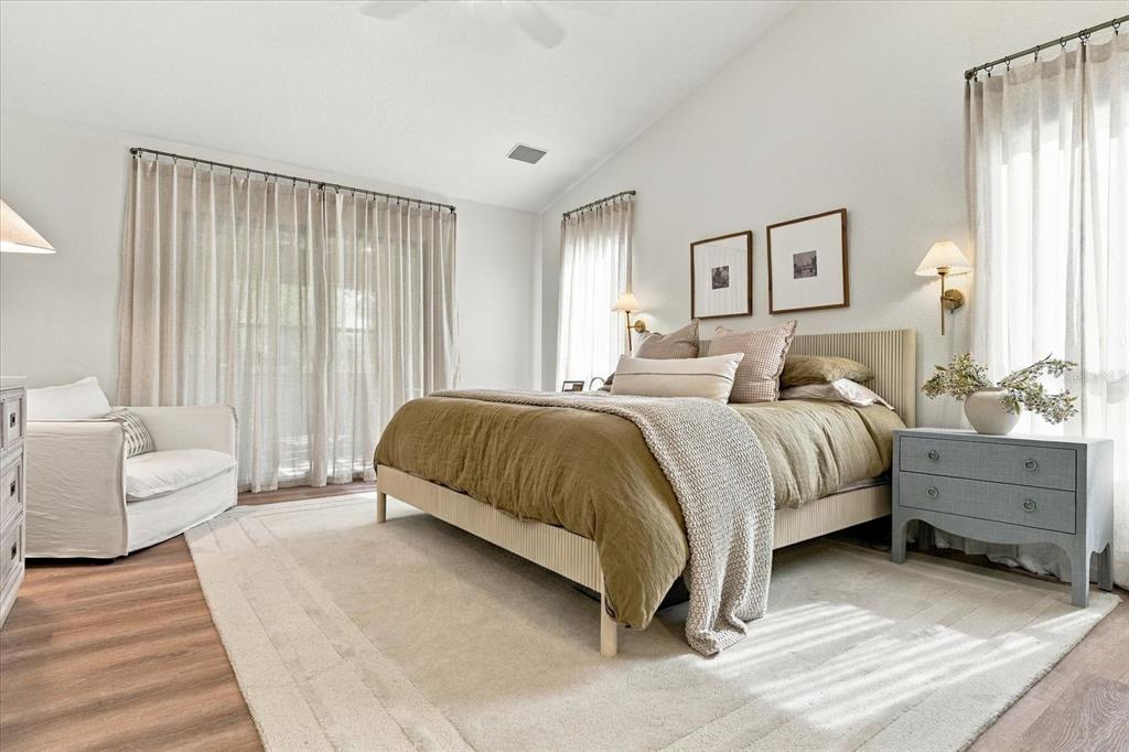 A bedroom features a bed with olive bedding, a light rug, and sheer window curtains — 1515 MIDNIGHT PASS WAY, CLEARWATER, FL