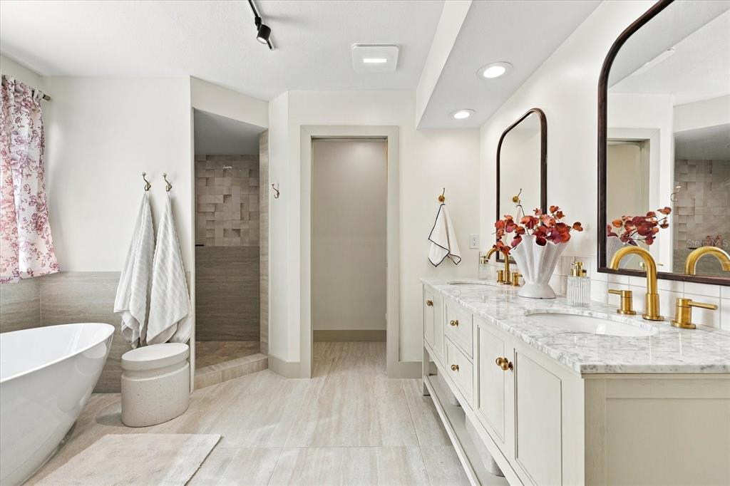 A bathroom features a double vanity with gold faucets, a soaking tub, and a shower — 1515 MIDNIGHT PASS WAY, CLEARWATER, FL