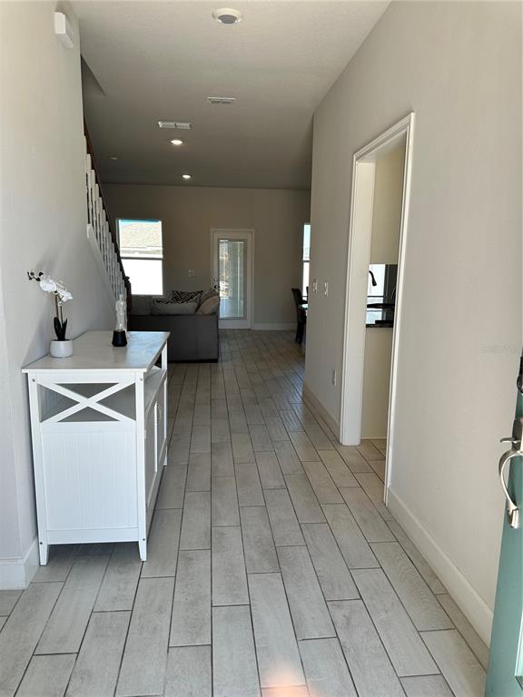 An entryway with light wood-look tile flooring leads to a living area and kitchen — 36097 WELSH GLADE ROAD, DADE CITY, FL