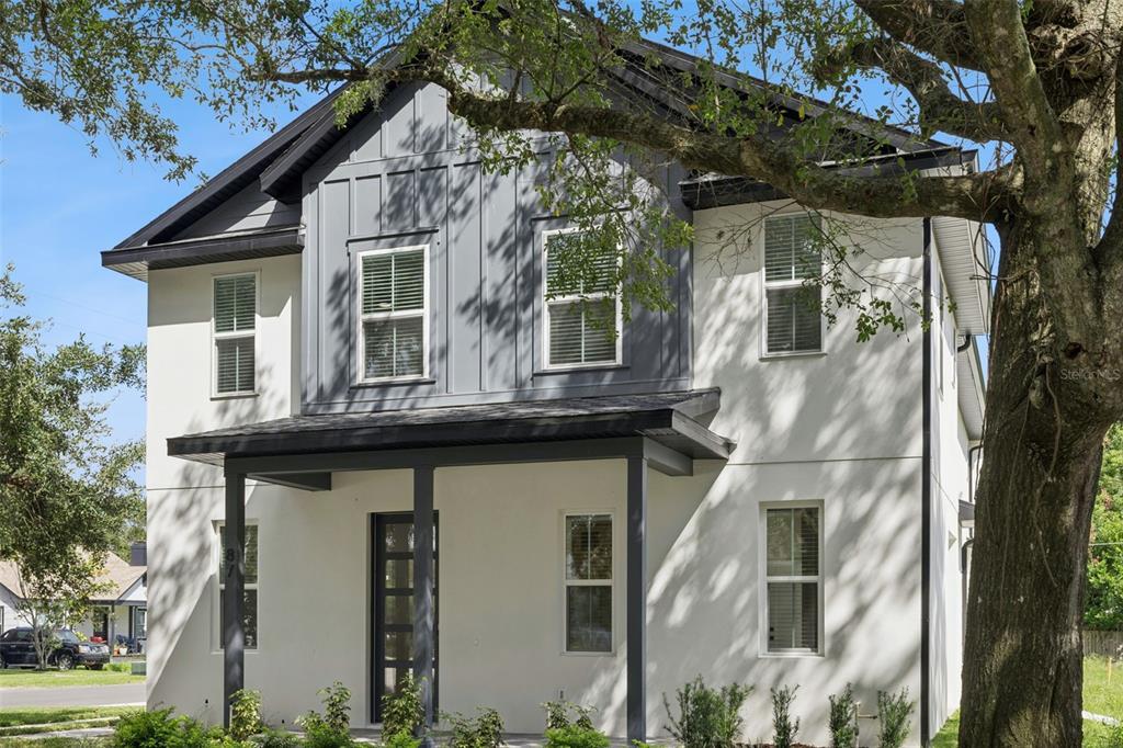 An entryway with light wood flooring, a modern pendant light, and a white front door — 87 W MURIEL STREET, ORLANDO, FL