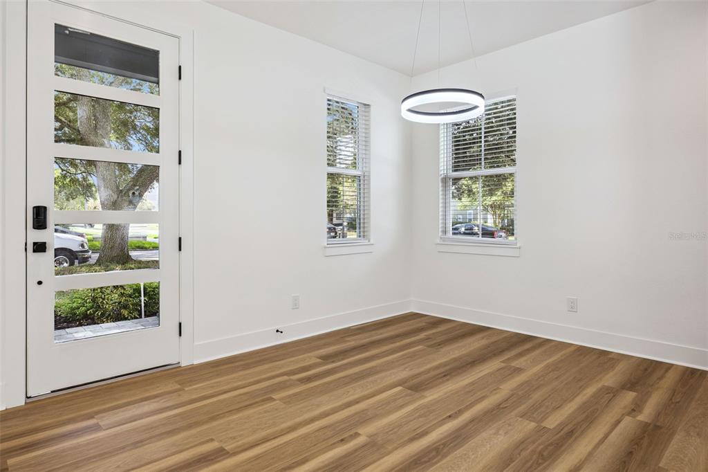 An open-concept living area features wood flooring, a modern kitchen, and a staircase — 87 W MURIEL STREET, ORLANDO, FL