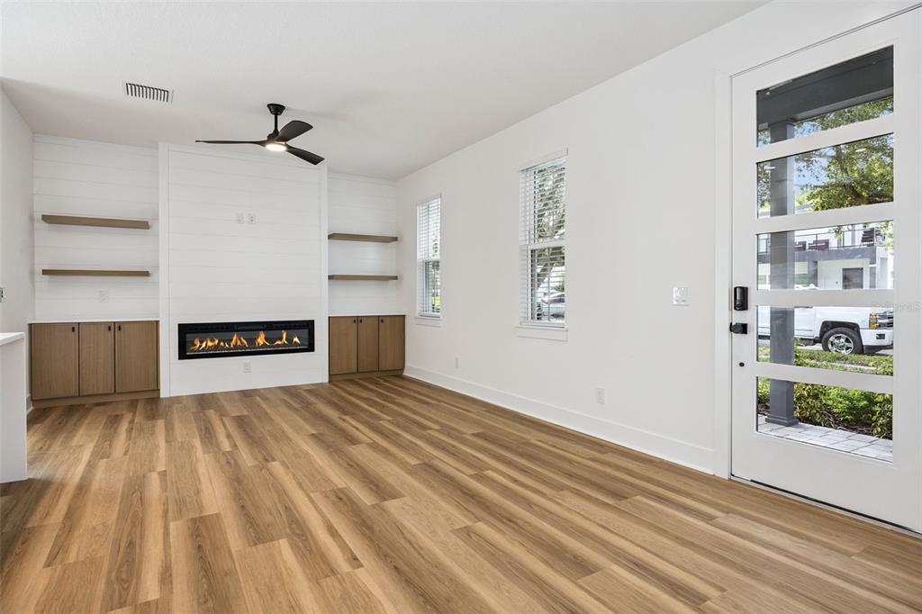 A living room features a fireplace, built-in cabinets, shiplap detailing, and light wood-look flooring — 87 W MURIEL STREET, ORLANDO, FL