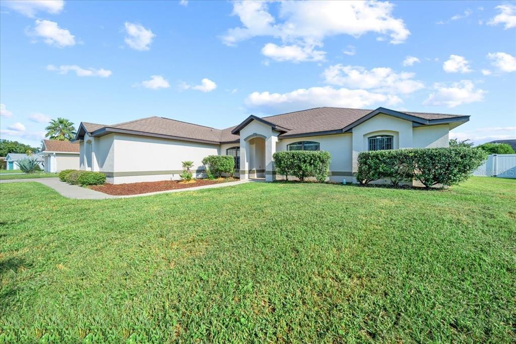 A single-story house with a beige stucco exterior, a brown roof, and a front lawn — 5659 SW 89TH PLACE, OCALA, FL