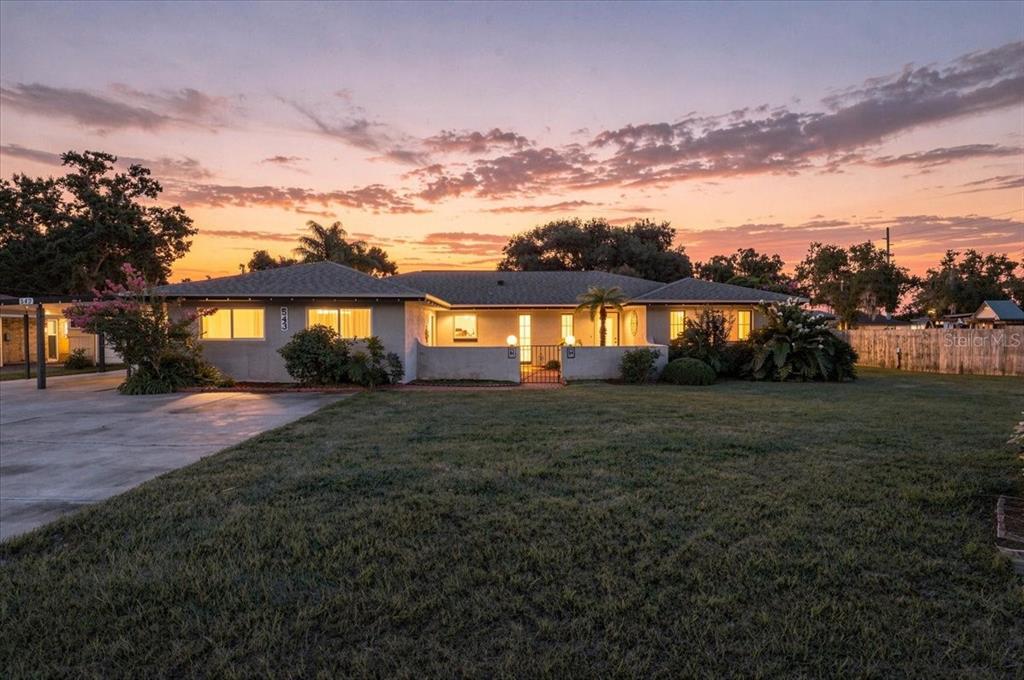 A single-story house with a low-pitched roof and a front courtyard at sunset — 543 STATE ROAD 559, AUBURNDALE, FL
