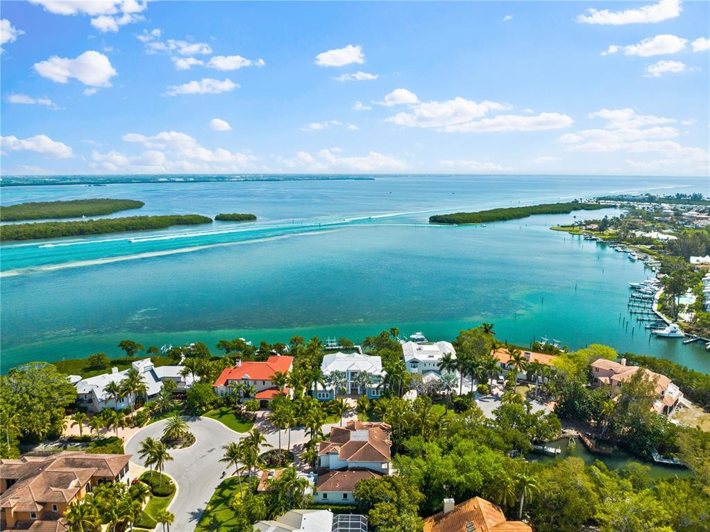 An aerial view of waterfront luxury homes surrounded by lush landscaping and a blue bay — 757 HIDEAWAY BAY DRIVE, LONGBOAT KEY, FL