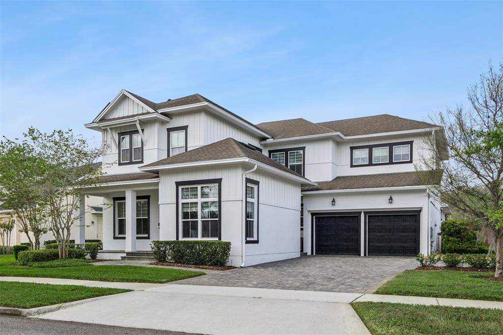 A swimming pool and spa are enclosed within a screened lanai behind a modern house — 14160 ELIOT AVENUE, ORLANDO, FL