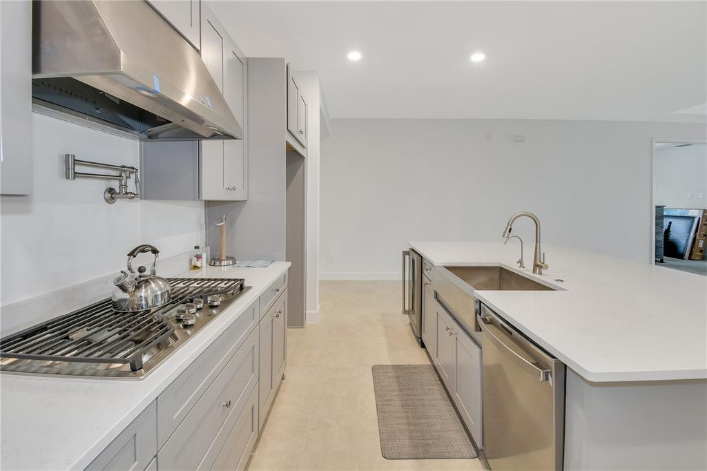 A modern kitchen features gray cabinets, white countertops, a gas range, and a center island — 1224 WATERVIEW RIDGE CIRCLE, APOPKA, FL