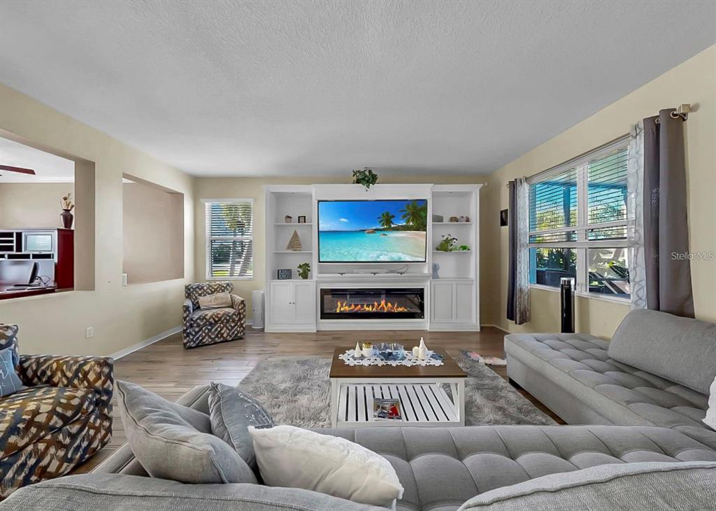 A living room features a large white entertainment center with a fireplace and a sectional sofa — 5457 SANDY SHELL DRIVE, APOLLO BEACH, FL