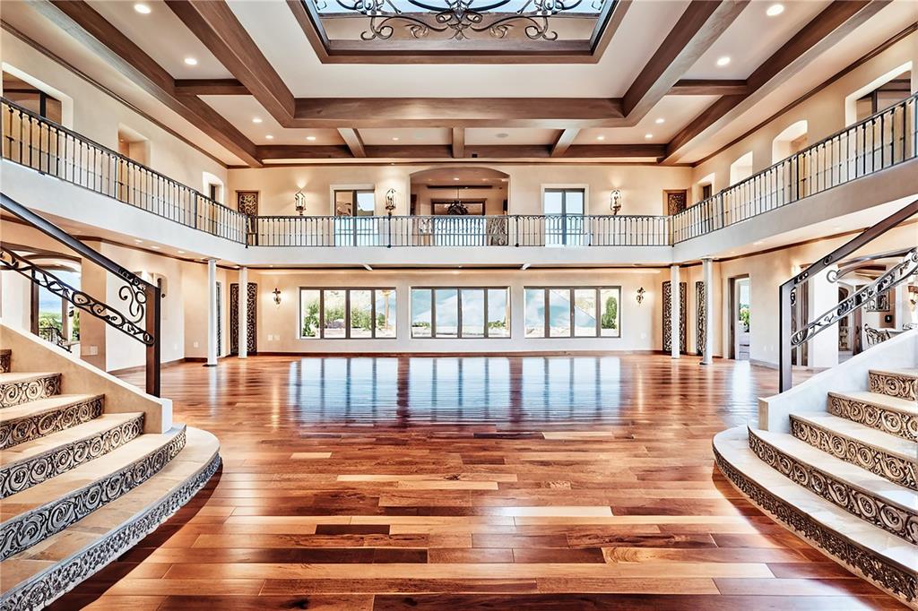 A grand ballroom features hardwood floors, dual staircases, and a balcony surrounding the upper level — 600 N JACKSON ROAD, VENICE, FL
