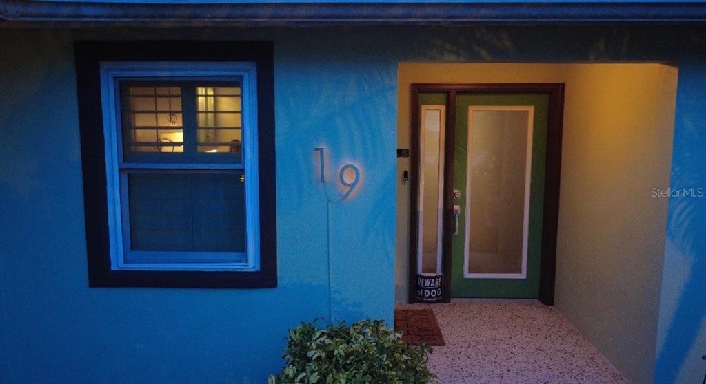 A blue exterior wall features a window, the house number 19, and a green door — 19 SANCHEZ AVENUE, ORMOND BEACH, FL