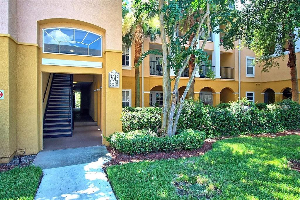 An exterior view of a multi-story apartment building with a staircase and landscaped grounds — 3615 CONROY ROAD UNIT 612, ORLANDO, FL