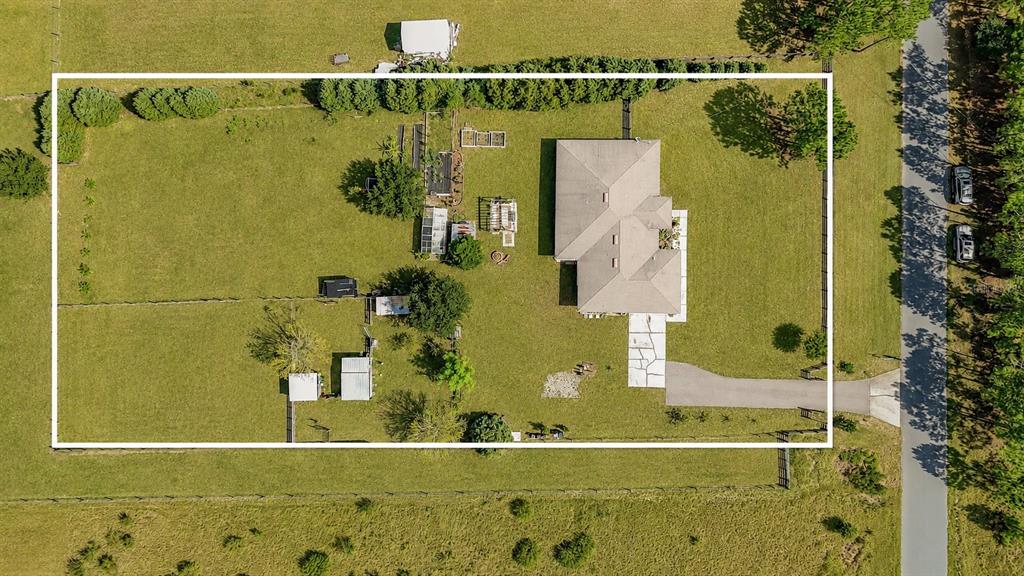 An aerial view shows a house on a large, fenced lot with outbuildings and trees — 18030 BAYAMON AVENUE, POLK CITY, FL