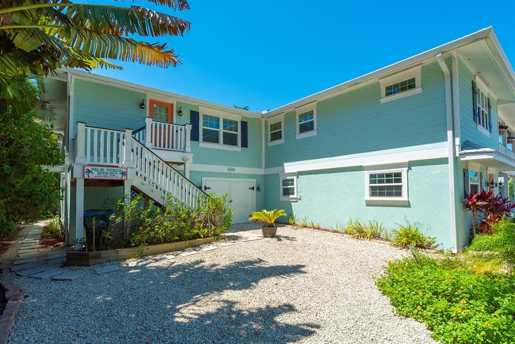 A two-story light blue house with a gravel driveway and an exterior staircase — 305 57TH STREET UNIT B, HOLMES BEACH, FL
