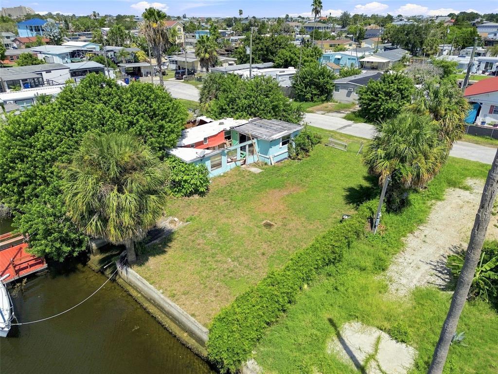 An aerial view of a waterfront property featuring a small house and a grassy yard — 6732 FLICKER LANE, HUDSON, FL