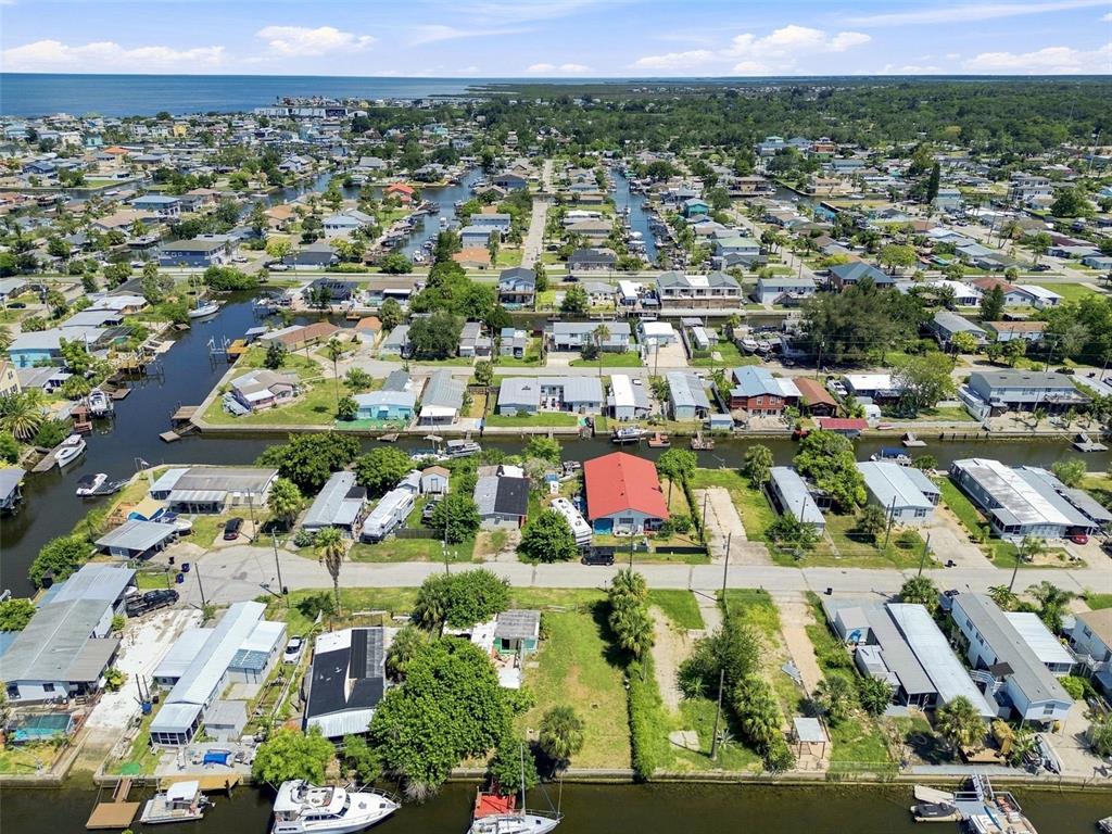 An aerial view shows a residential neighborhood with houses situated along narrow canals and waterways — 6732 FLICKER LANE, HUDSON, FL