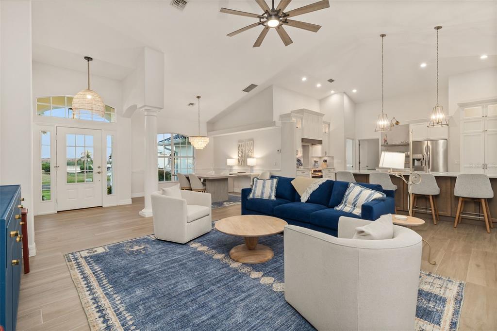 An open-concept living room features a blue sofa, two armchairs, and a kitchen island — 495 CORAL CREEK DRIVE, PLACIDA, FL