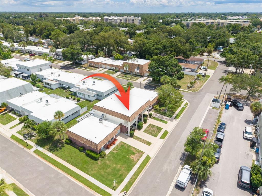 An aerial view shows a flat-roofed building with a red arrow pointing to its roof — 802 MINDY COURT UNIT 802, LARGO, FL