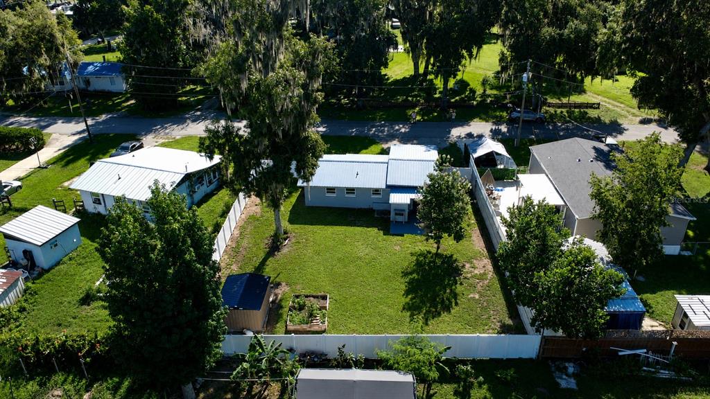 An aerial view shows a residential backyard with a lawn, a shed, and several houses — 1924 CR 439C, LAKE PANASOFFKEE, FL