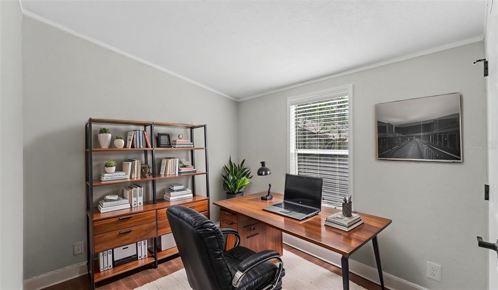 A home office features a wooden desk, a black leather chair, and a tall bookshelf — 1222 ROWELL STREET, AUBURNDALE, FL