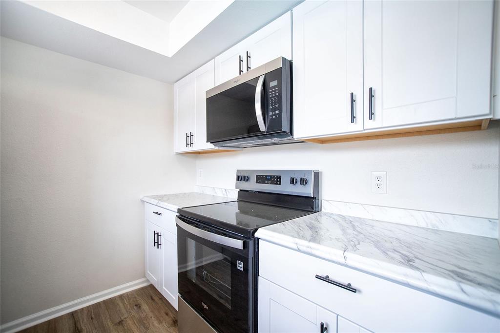 An empty room with wood-look flooring, a ceiling fan, and two cardboard boxes — 6062 22ND AVENUE N UNIT 5, ST PETERSBURG, FL
