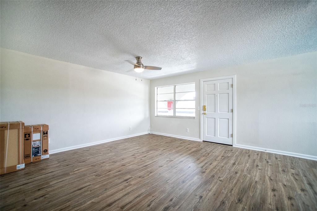 An empty bedroom features light-colored walls, wood-look flooring, a ceiling light, and a window — 6062 22ND AVENUE N UNIT 5, ST PETERSBURG, FL