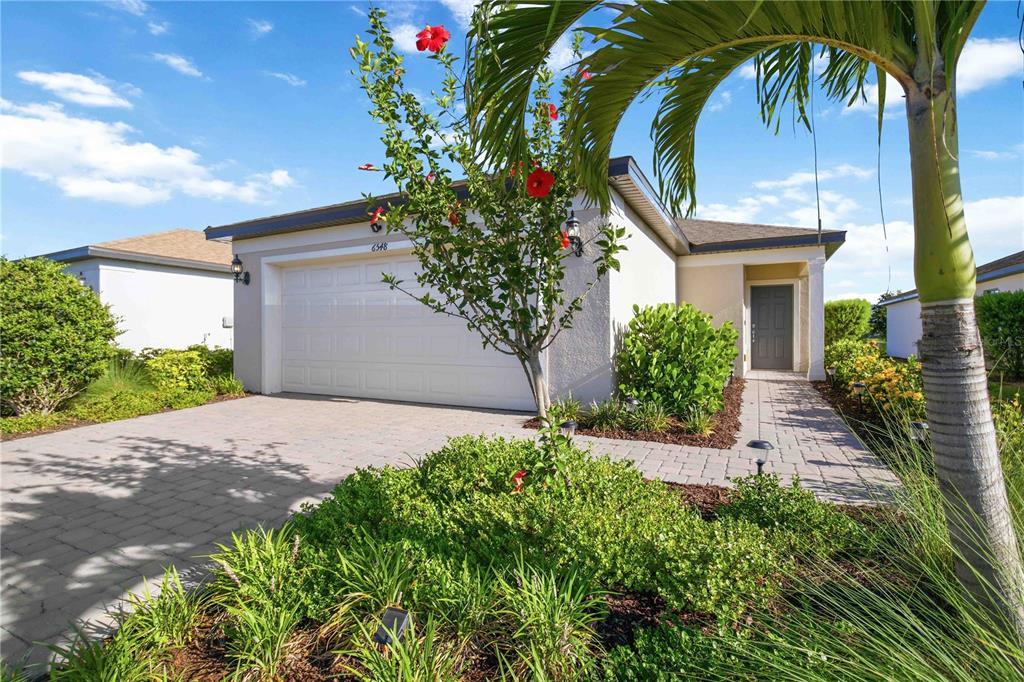 A single-story house with a paved driveway, a two-car garage, and a landscaped front yard — 6548 SILVERSTAR DRIVE, SARASOTA, FL