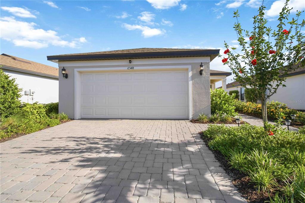 A paved driveway leads to a single-story house with a two-car garage — 6548 SILVERSTAR DRIVE, SARASOTA, FL