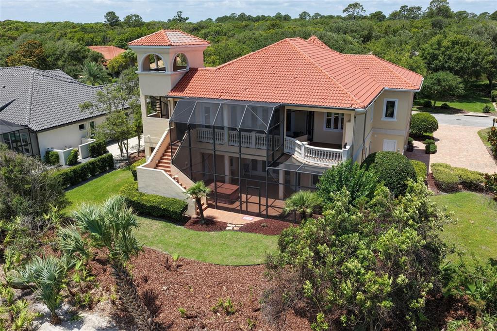 An aerial view of a two-story house with a red tile roof and screened-in patio — 44 OCEAN OAKS LANE, PALM COAST, FL
