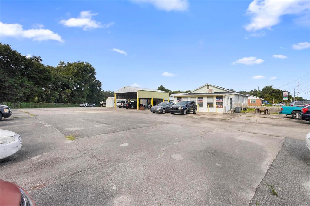 An exterior view of a commercial property with a parking lot and a service bay — 2490 N WOODLAND BOULEVARD, DELAND, FL