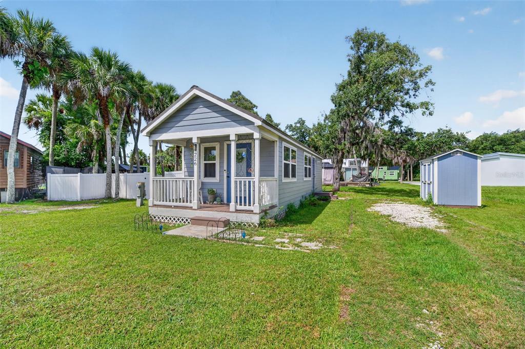 A small, light blue house with a front porch sits on a grassy lot — 226 FLAMINGO DRIVE, COCOA, FL