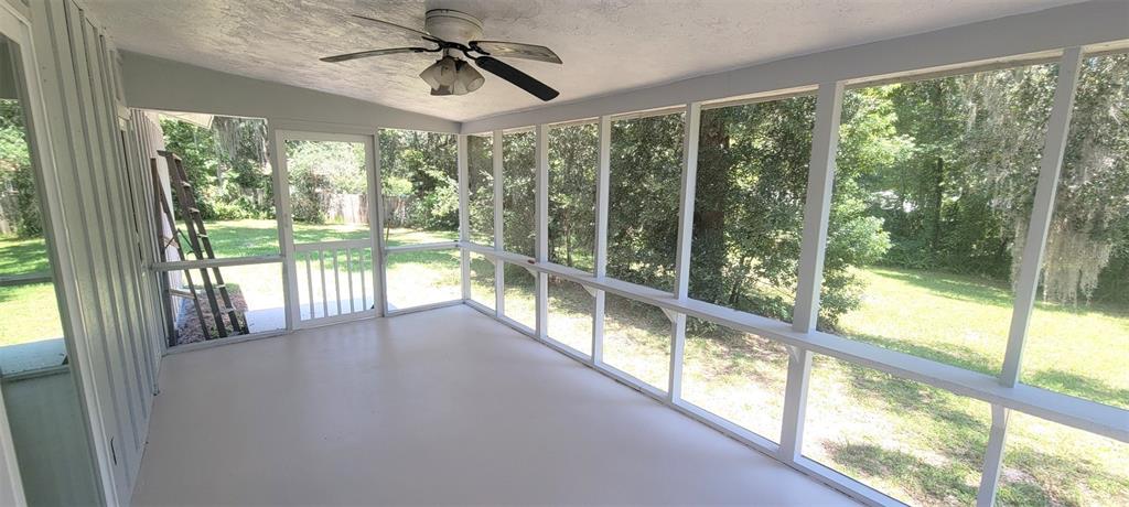 A kitchen features gray cabinets, stainless steel appliances, a stone backsplash, and light-colored flooring — 1965 MANOR WAY, DELAND, FL