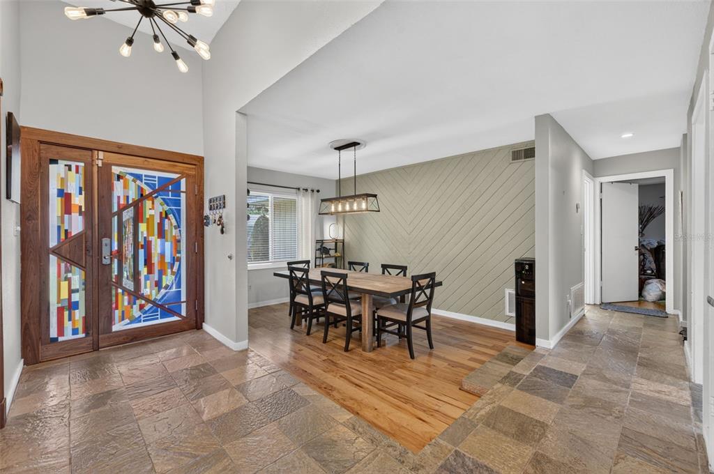 A dining area with a wood table and chairs sits on a hardwood floor transition — 120 SLADE DRIVE, LONGWOOD, FL