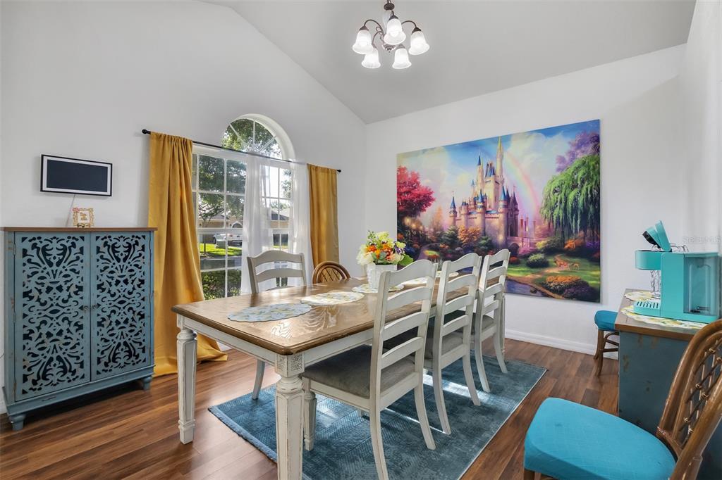 A dining room features a wooden table, six chairs, a large castle mural, and blue accents — 17833 WOODCREST WAY, CLERMONT, FL