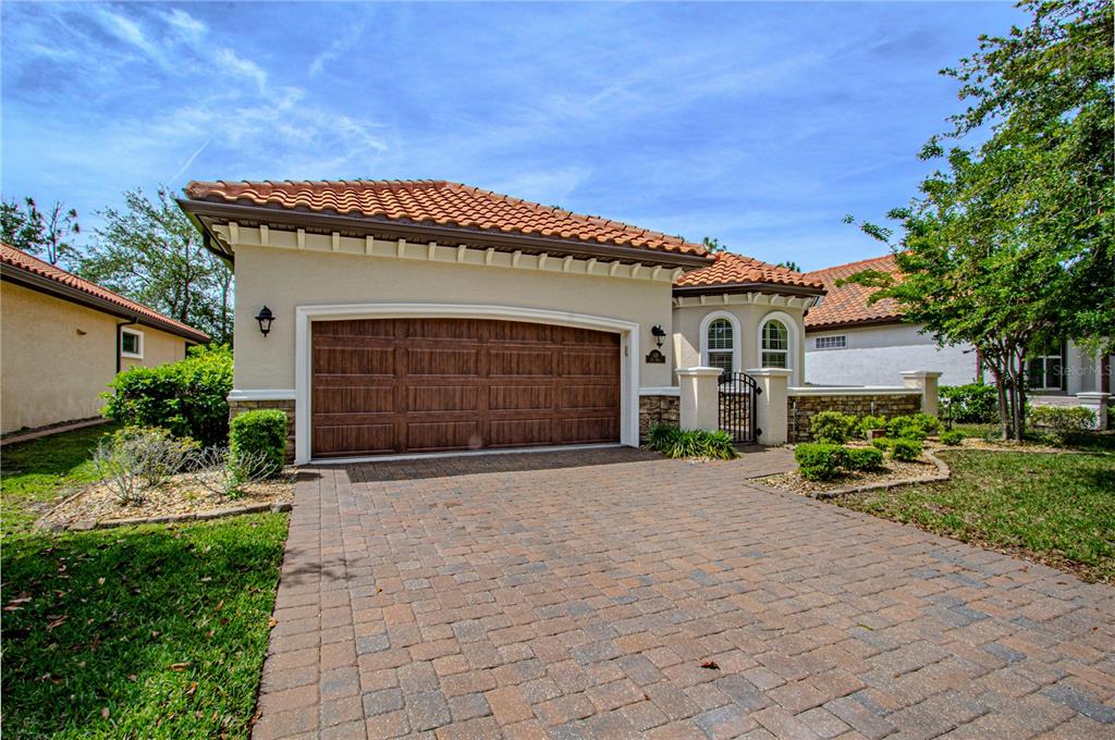 A tan house with a brown tile roof and a large two-car garage — 108 VIA ROMA, ORMOND BEACH, FL