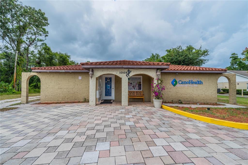 A single-story building with a tiled roof, stucco exterior, and a paved front entrance — 10508 GIBSONTON DR, RIVERVIEW, FL