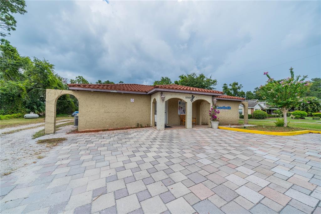 A single-story building with a stucco exterior, tile roof, and a paved parking lot — 10508 GIBSONTON DR, RIVERVIEW, FL