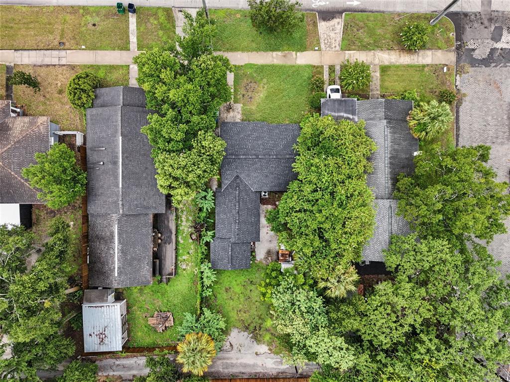 An aerial view shows two adjacent houses with dark shingled roofs and surrounding trees — 6317 N CENTRAL AVENUE, TAMPA, FL