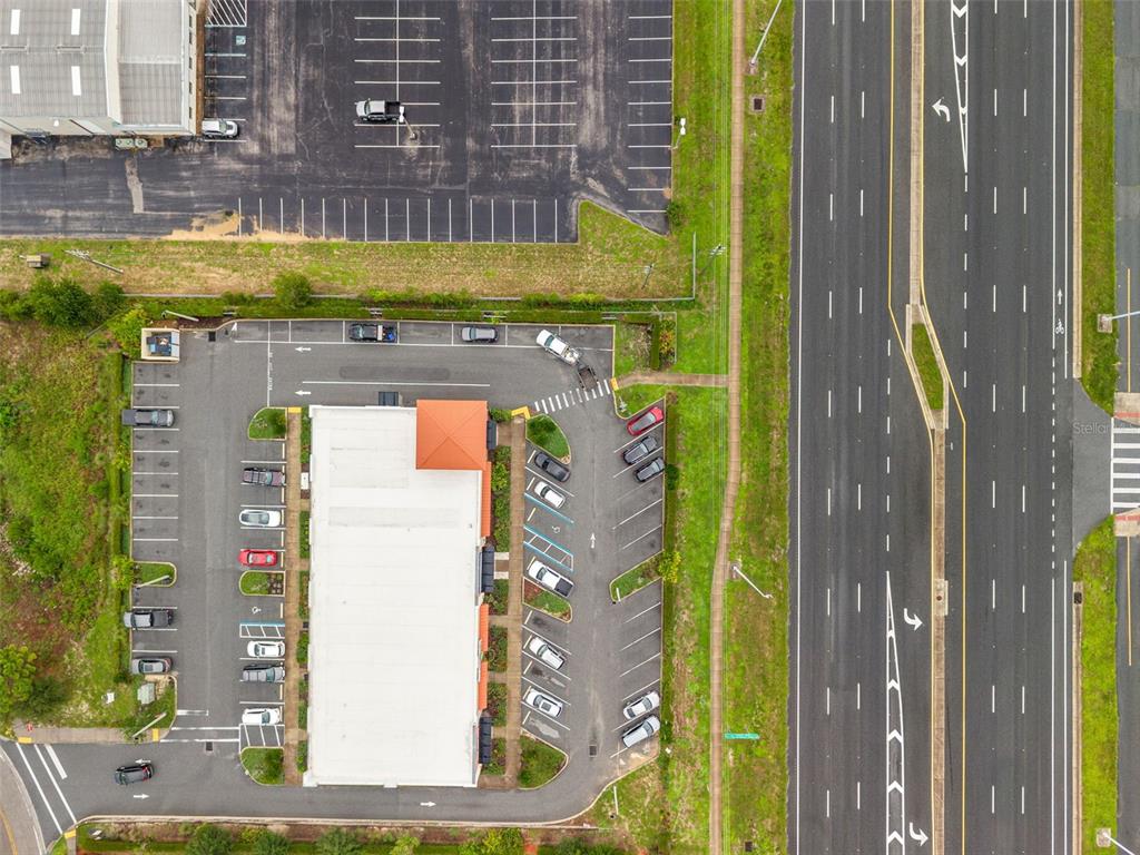 An aerial view shows a commercial building with a parking lot next to a highway — 14111 CORTEZ BOULEVARD, BROOKSVILLE, FL