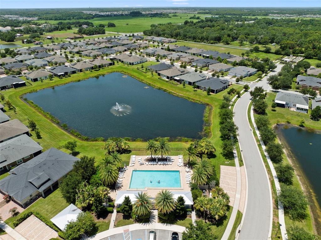 Aerial view of a residential neighborhood featuring a community swimming pool and a large pond — 2516 DATURA LOOP, ST CLOUD, FL