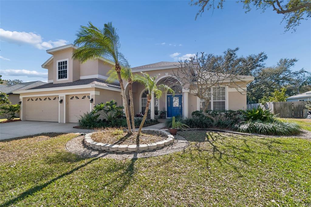 A two-story house with a three-car garage, arched entryway, and a blue front door — 928 OAKVIEW ROAD, TARPON SPRINGS, FL