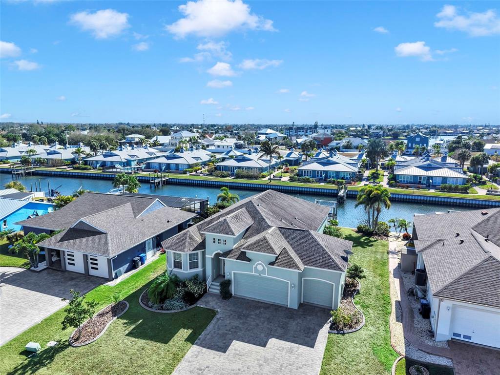 An aerial view shows a light green house with a multi-car garage near a canal — 916 SPINDLE PALM WAY, APOLLO BEACH, FL